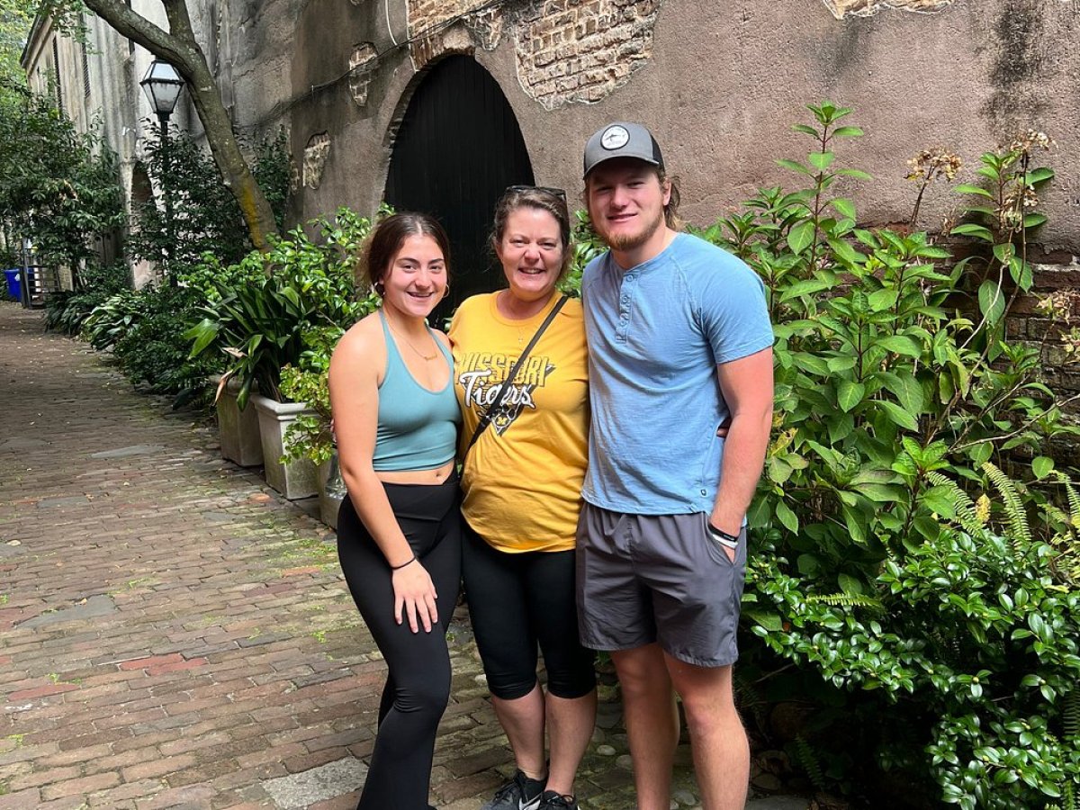 a man and a woman standing in front of a brick building