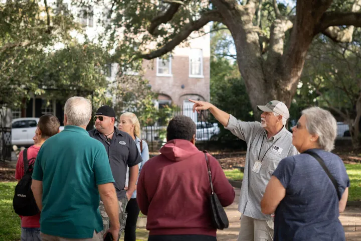a group of people standing next to a tree