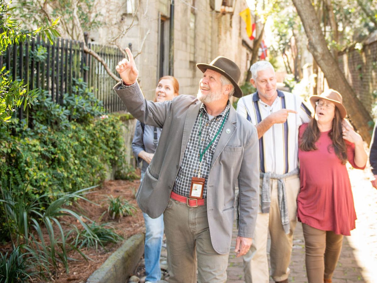 a group of people standing next to a tree