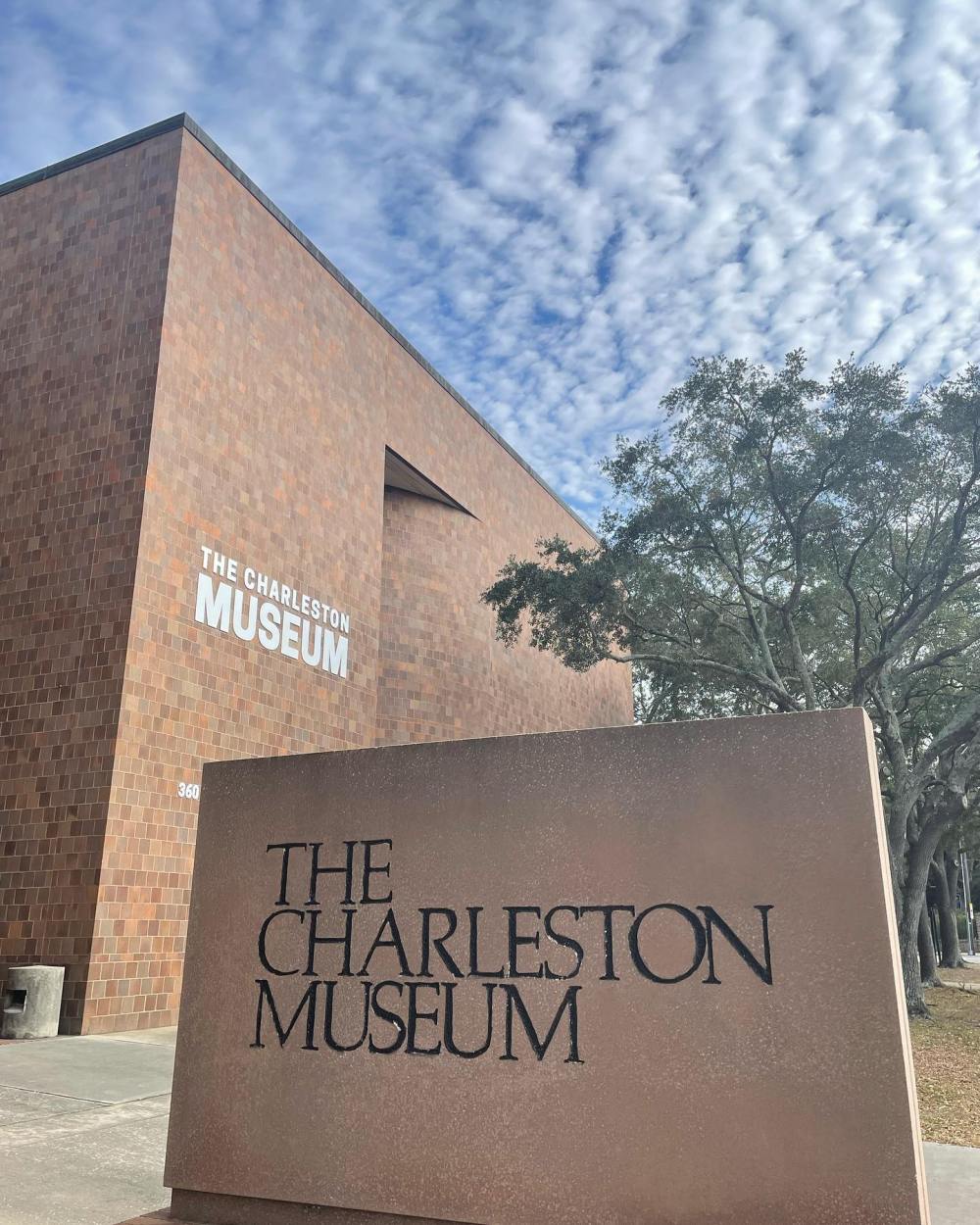 Entrance sign and building of The Charleston Museum under a cloudy sky.